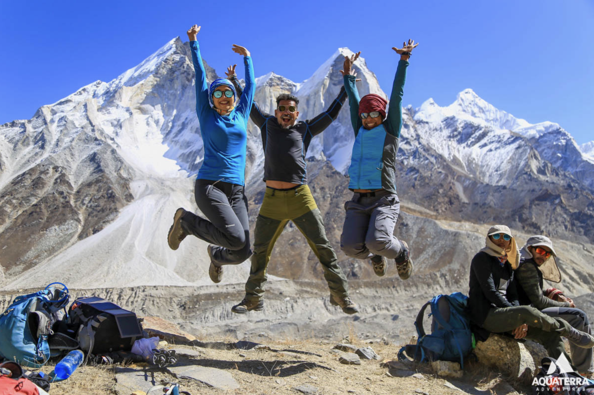 hikers jumping up in the air, mountains in the background