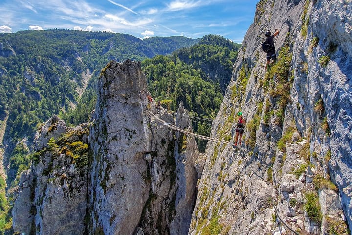 climbers posing on a via ferrata bridge