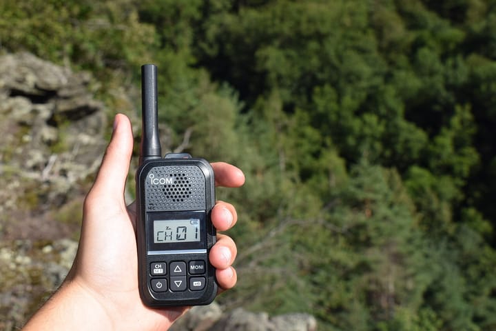 a hand holding a walkie talkie radio