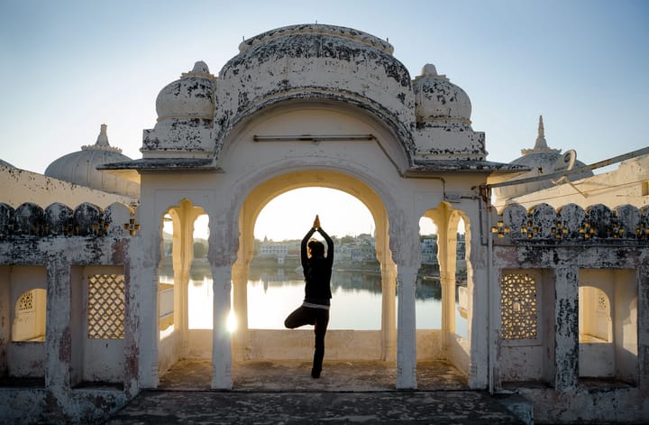 a person does yoga in an Indian temple at dawn